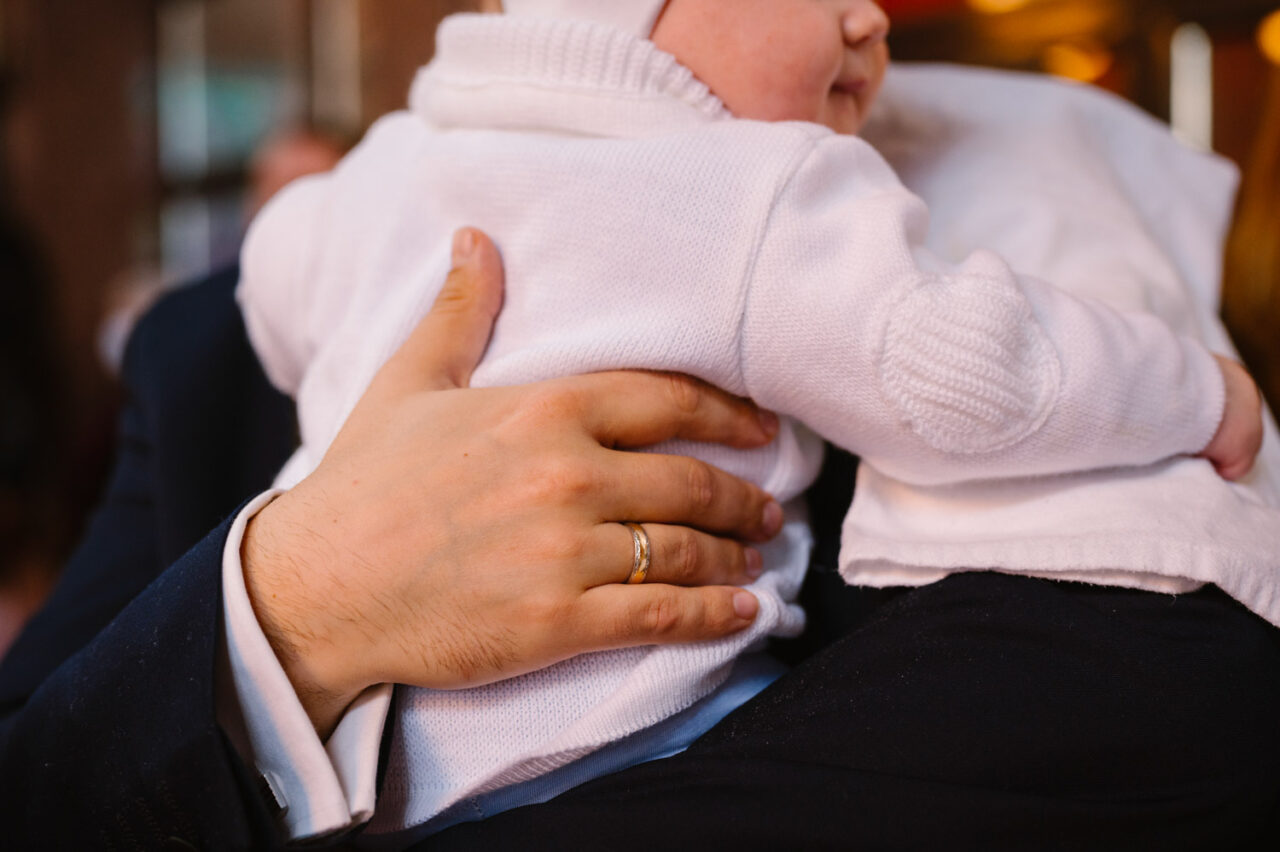 dłoń ojca obejmującego dziecko