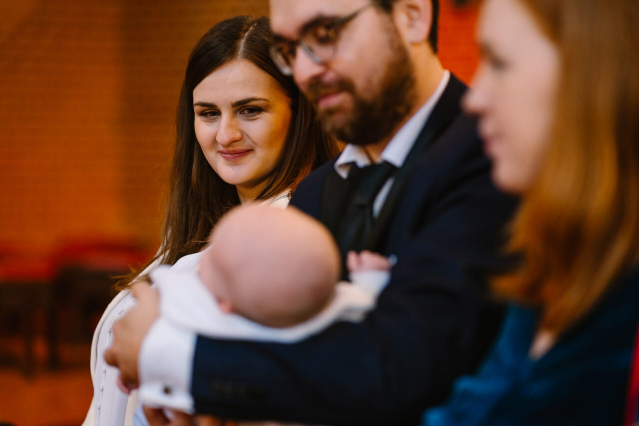mama spogląda na dziecko podczas chrztu