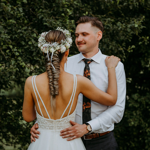 pan młody przytula żonę na tle drzew