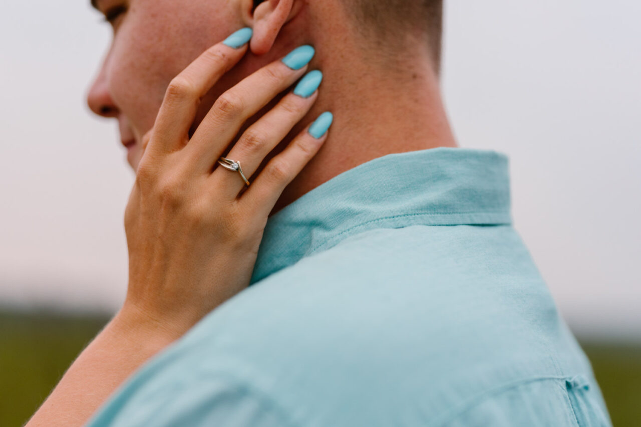 kobieca dłoń z pierścionkiem na twarzy ukochanego