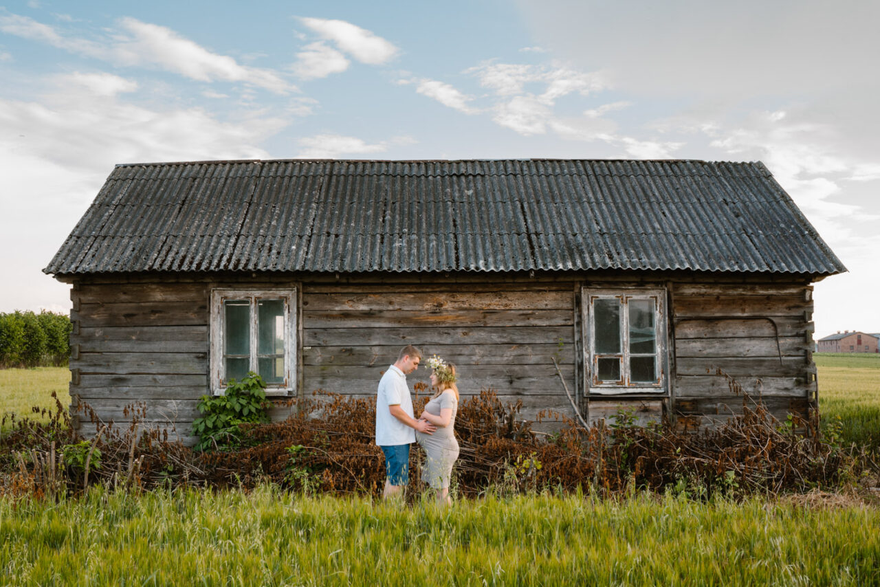 młode małżeństwo na tle drewnianej chałupy