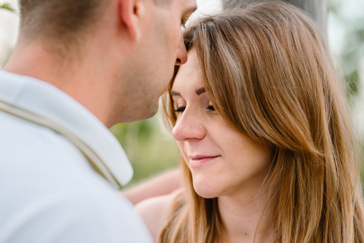 mężczyzna całuje w czoło swojążonę