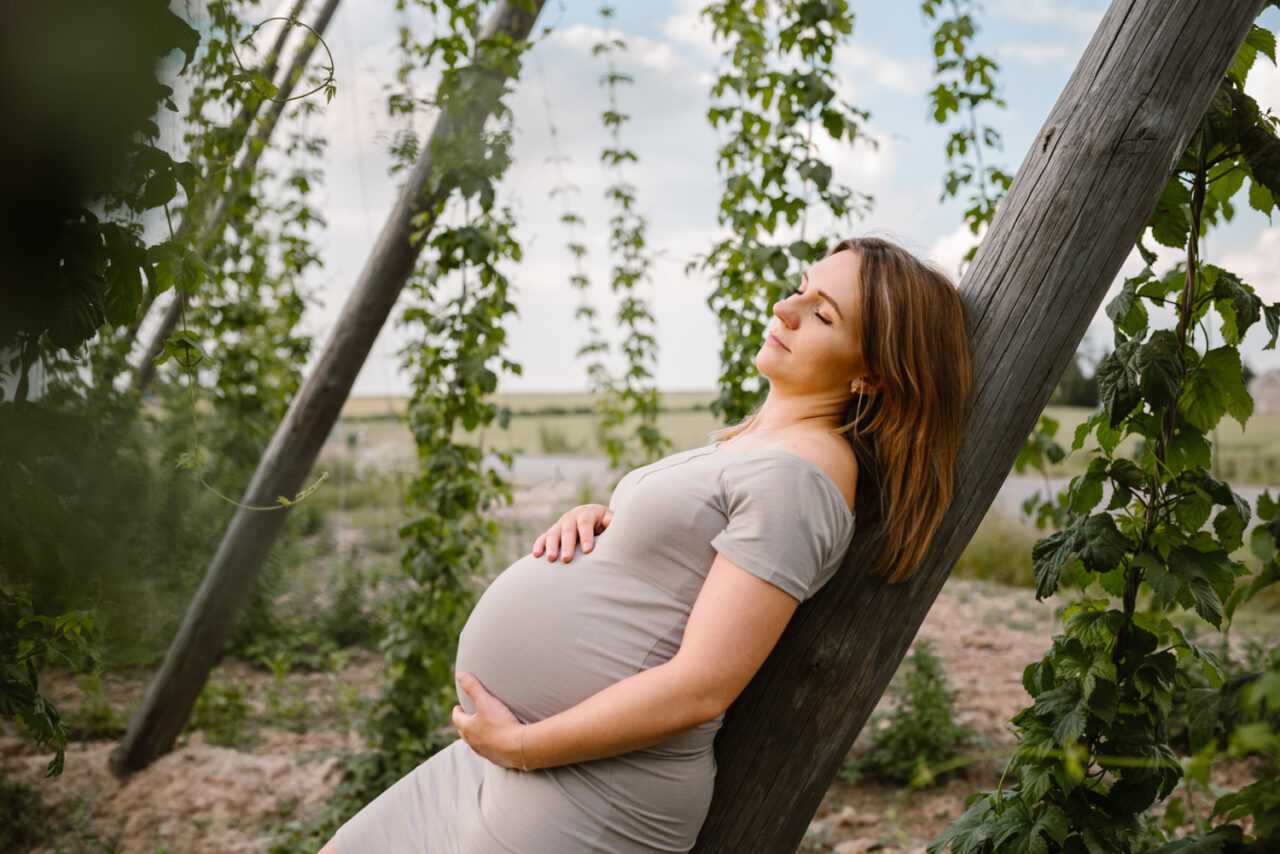 mam z brzuszkiem ciążowym leży wśród pnączy