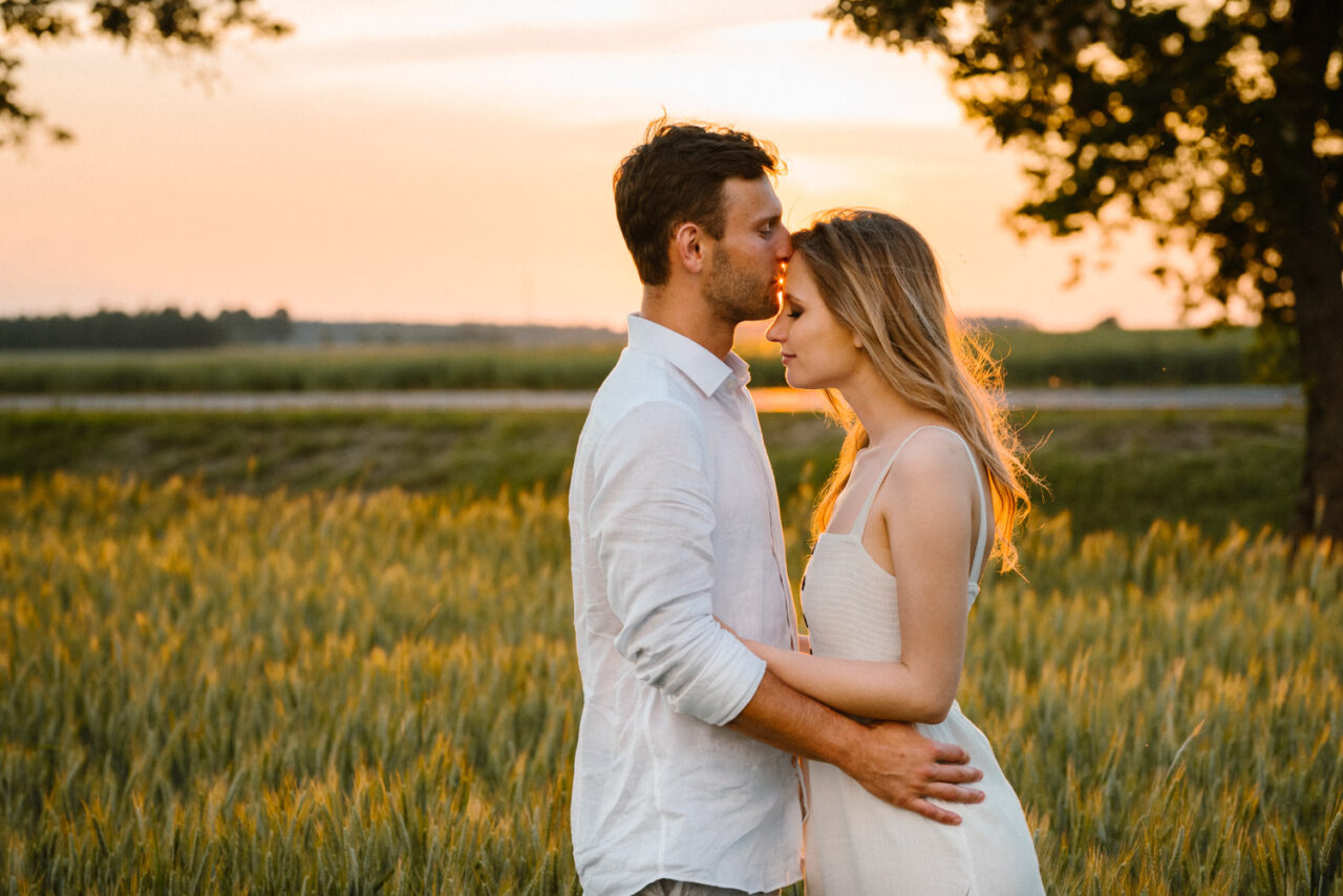 para narzeczonych na tle pól o zachodzie słońca