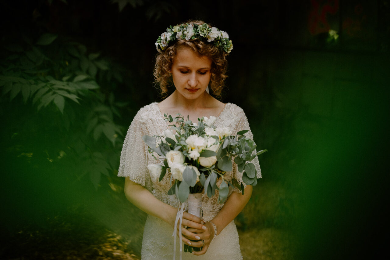 panna młoda we wianku trzyma bukiet ślubny