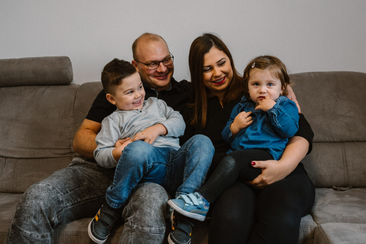 uśmiechnięta rodzina siedzi na kanapie